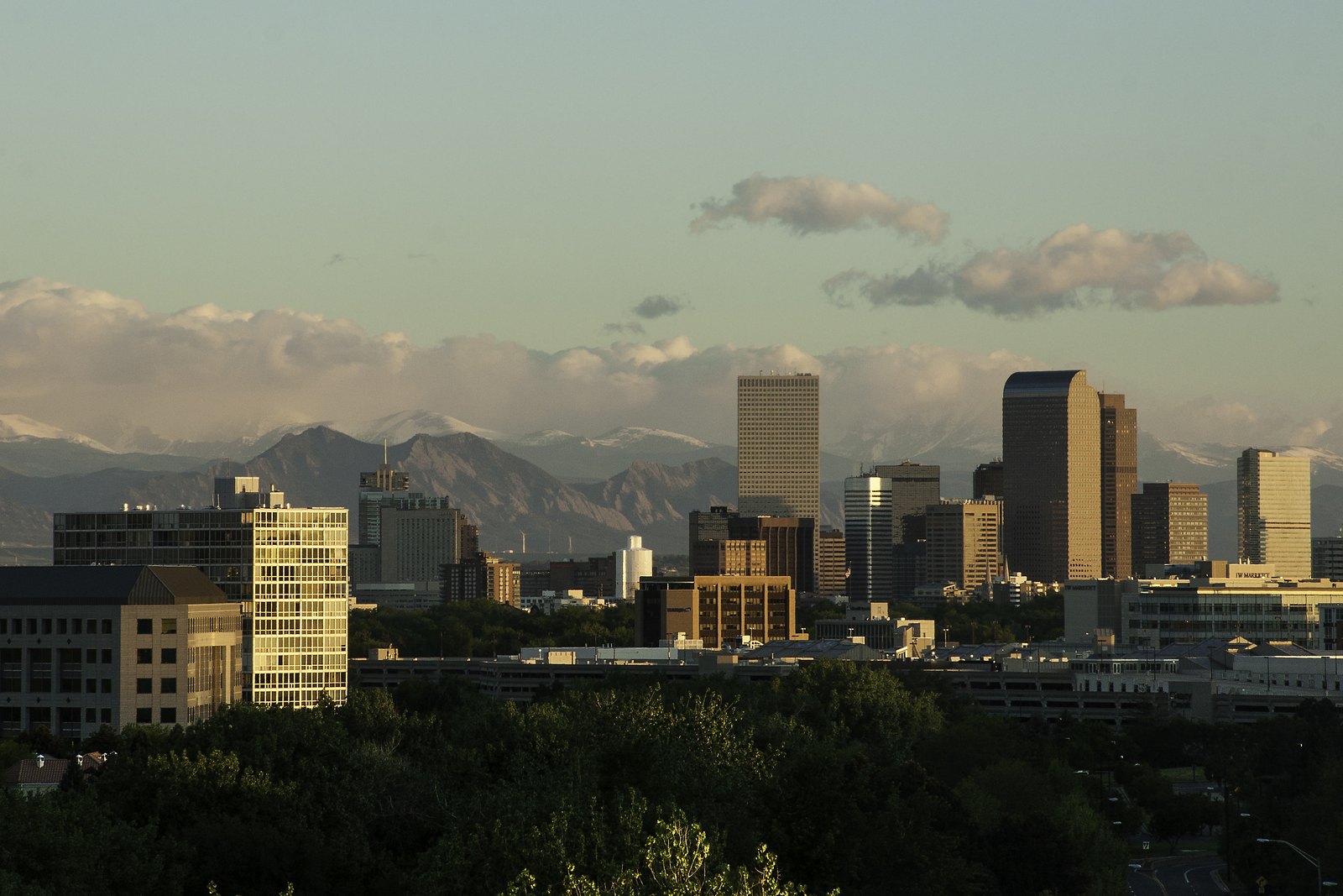 Downtown Denver at sunset, with snow on the Front Range behind it
